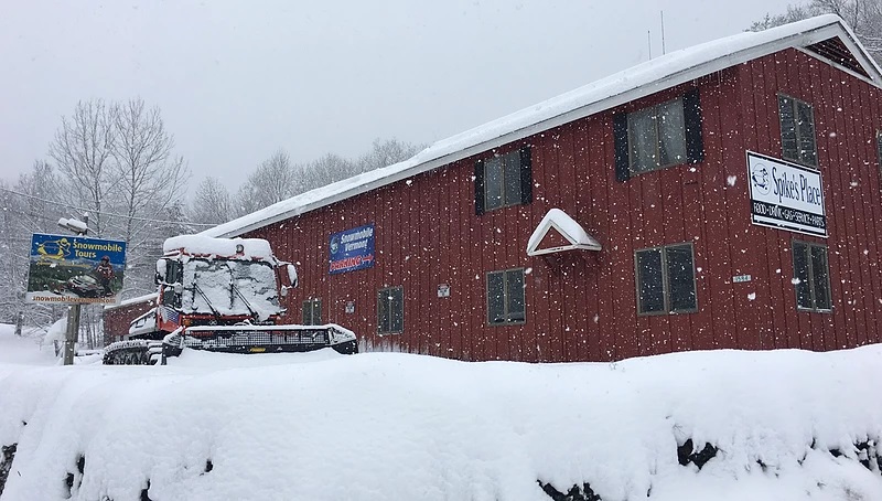 8bc2a8_1434c751a84a4417a3f1a1e98d27dde1_mv2_d_2208_1242_s_2 a building covered in snow