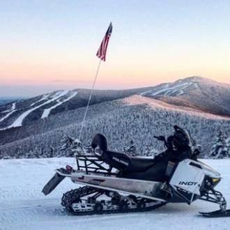 a group of people sitting on top of a snow covered mountain